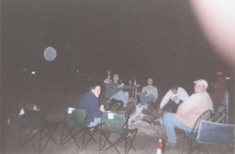 People seated around a campfire at night