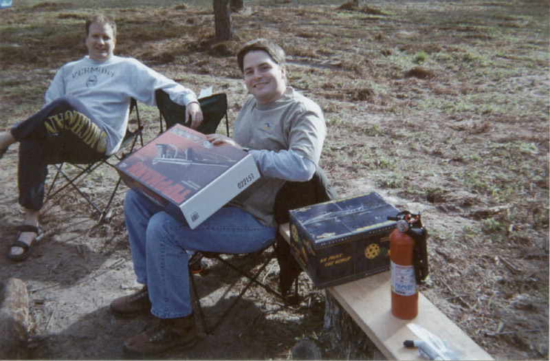 Two people seated with supplies on folding chairs