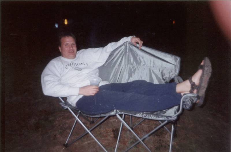 Camper reclining in a folding chair at night