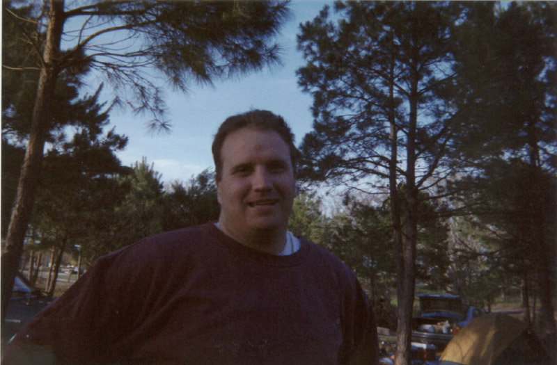 Portrait of a person seated outdoors among trees