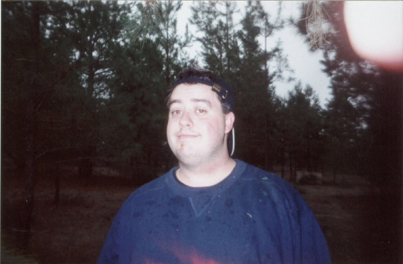Portrait of a person in a blue shirt at camp