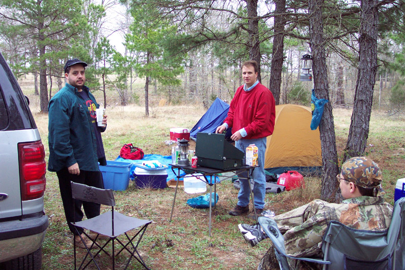 Campers gathered beside tents and a supply table