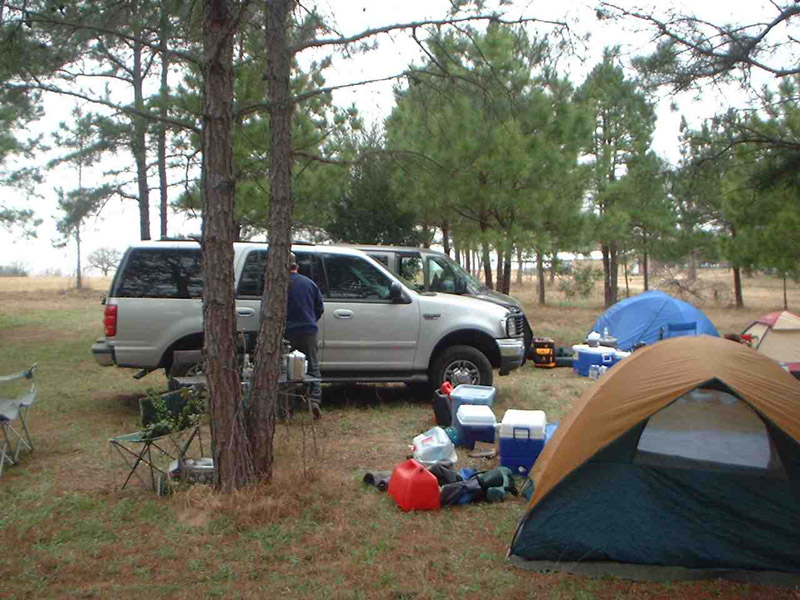 Tent and camping supplies beside a pickup truck