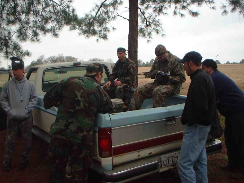 Players gathered around the bed of a pickup truck