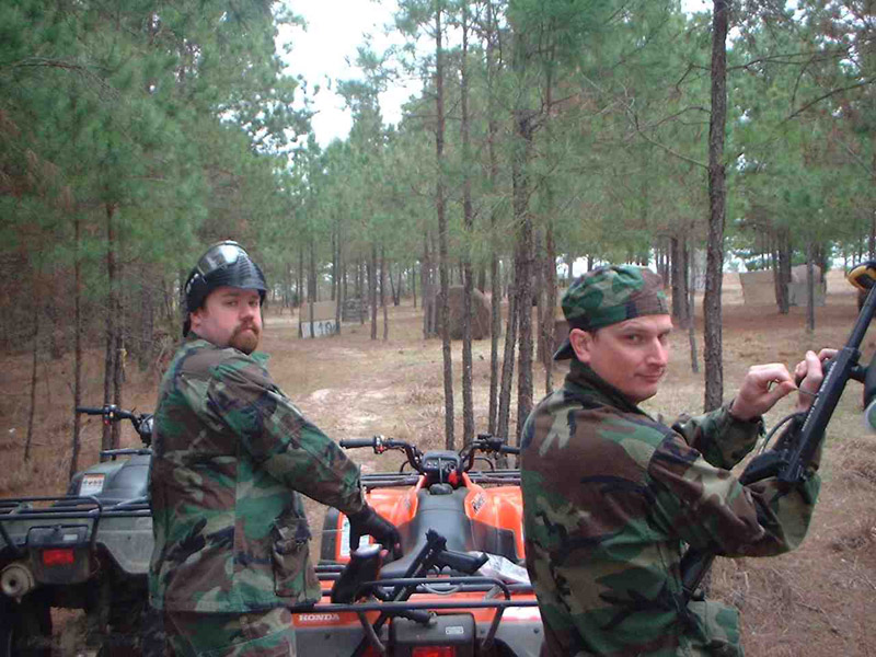 Two camouflaged players beside an all-terrain vehicle
