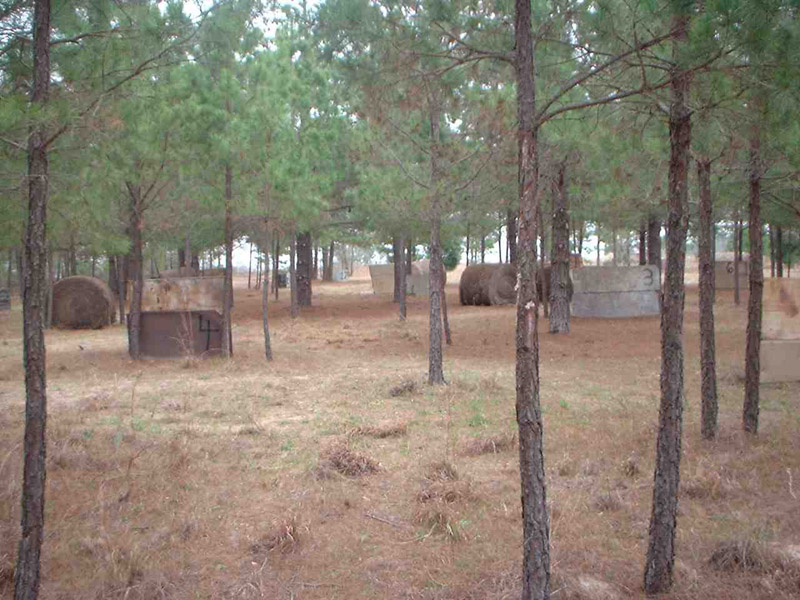 Wooded paintball field with cable reels and low barriers