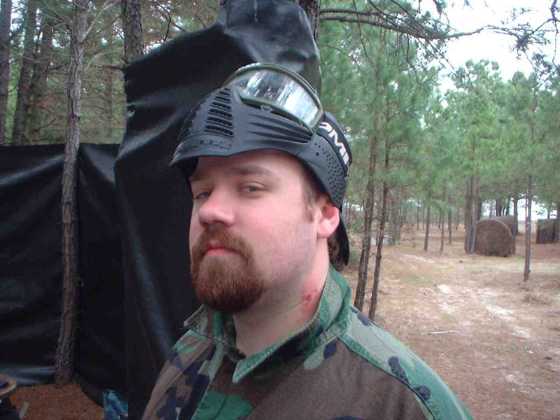 Camouflaged player with a protective mask raised above their face