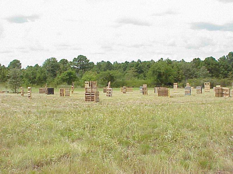 Wooden barriers spread across a field beneath a cloudy sky